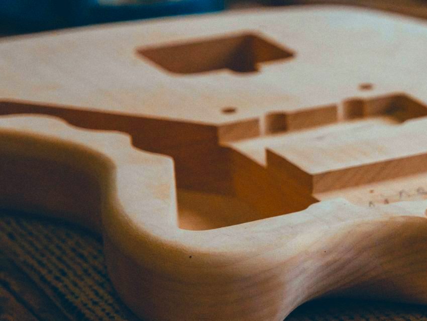 An unfinished guitar body on the workbench